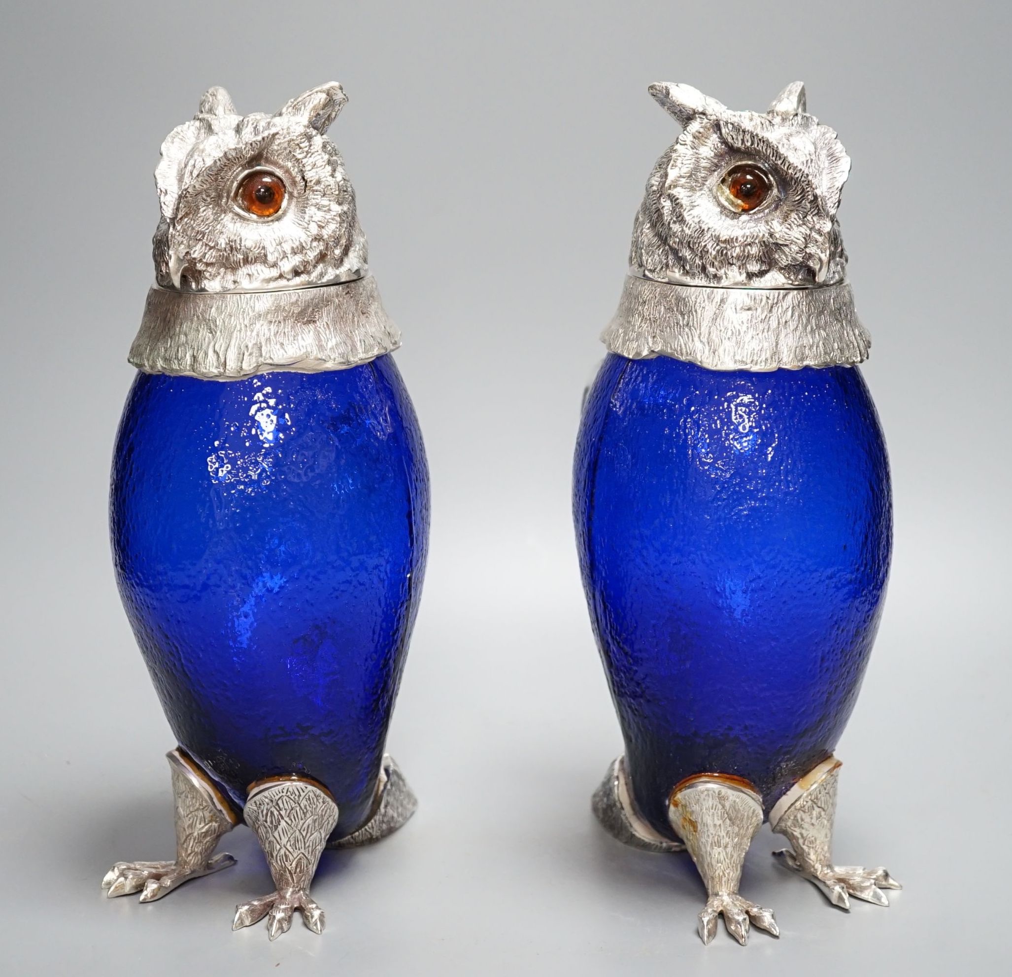 A pair of modern silver plated and blue glass novelty owl flasks, 28.5 cms high.